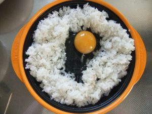 プレートに白ご飯と生卵の写真