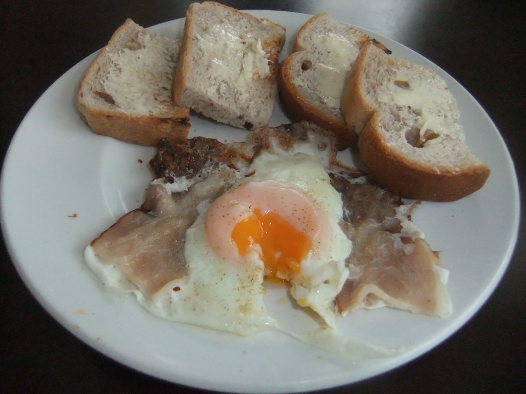 お皿に焼いたパンと、目玉焼きをのせた写真

