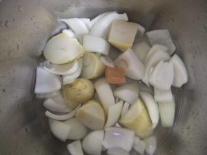 鍋に玉ねぎ、ジャガイモが入っている写真