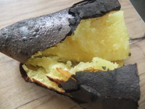 焦げた焼きいもを手で割いた写真