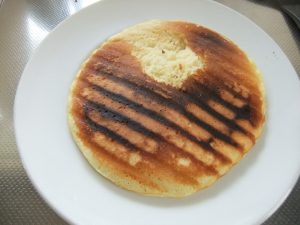 お皿に少し焦げたホットケーキがのった写真