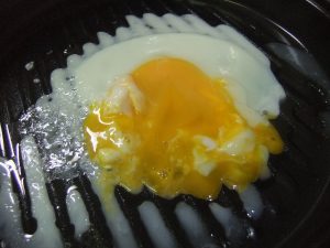プレートの上に崩れた目玉焼きがのっている写真