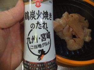 鶏炭火焼きのたれの写真。奥のプレートに鶏肉がのっているのが写っています。