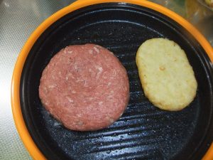 プレートに生のハンバーグとハッシュポテトがのっている写真