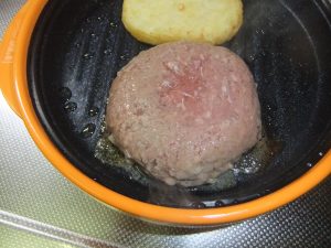 プレートに焼きかけのハンバーグとハッシュポテトがのっている写真