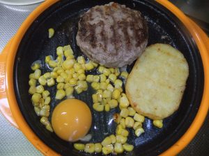 プレートにハンバーグと付け合わせの材料がのっている写真