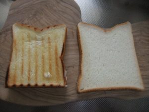 まな板にトーストされた食パンとそのままの食パンがのっている写真