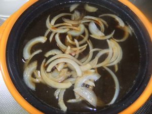 プレートに薄切り玉ねぎと、だしが入った写真