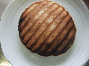 お皿に濃い焼き目のホットケーキの写真