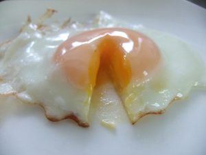 目玉焼きの黄身の部分を切った写真