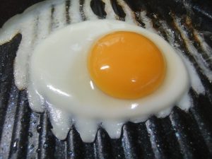 プレートに調理途中の目玉焼きの写真
