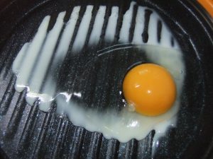 プレートに調理途中の目玉焼きの写真