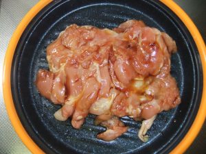 プレートに味の付いた調理前の鶏肉の写真